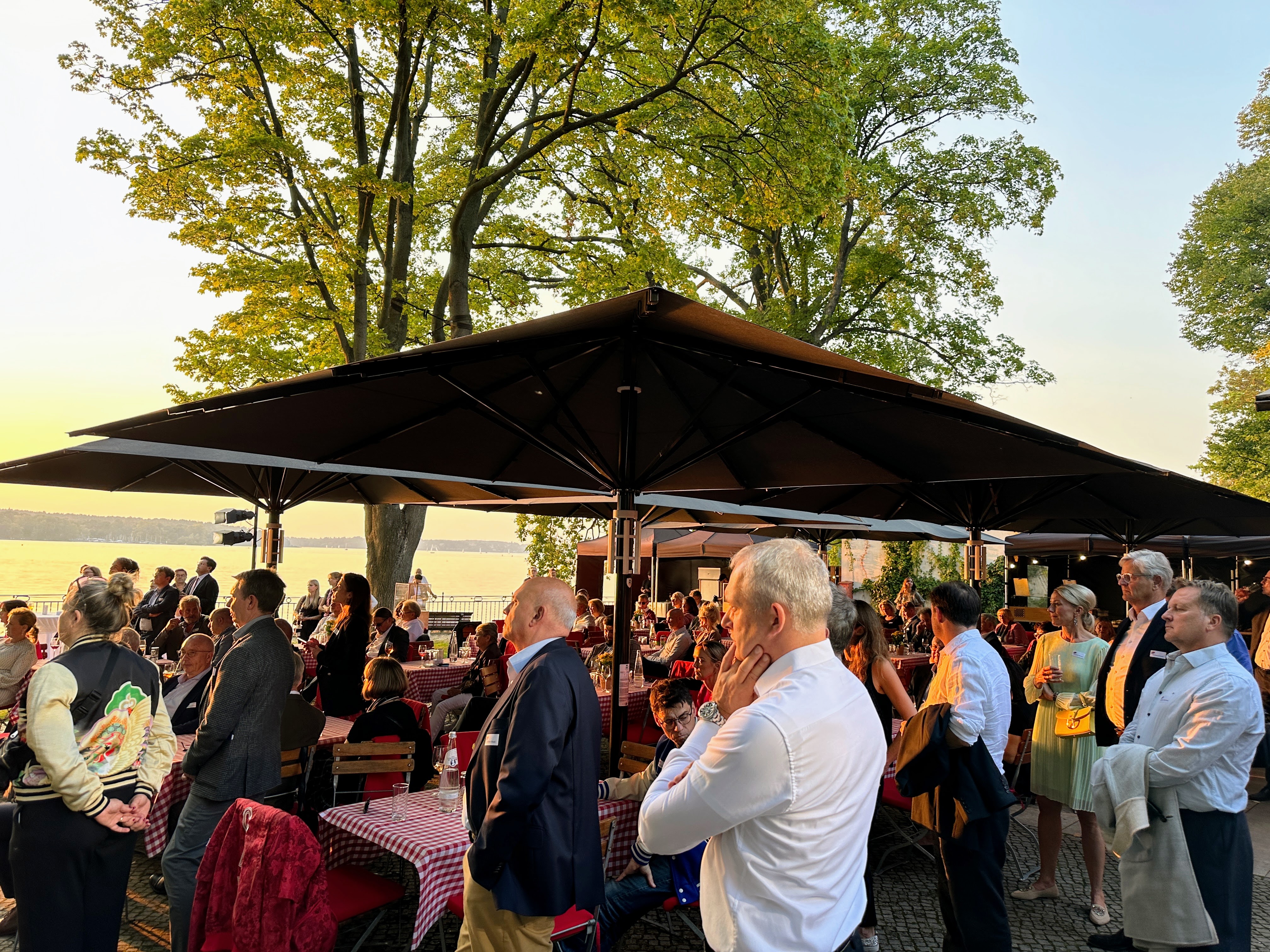 Die Gäste des Sommerempfangs der Berliner Wirtschaftsgespräche genießen den wunderschönen Sonnenuntergang über dem Wannsee. Ein Abend, an dem nicht nur die Natur, sondern auch die wirtschaftlichen Gespräche in Richtung einer gesunden Zukunft führten | BERLINboxx