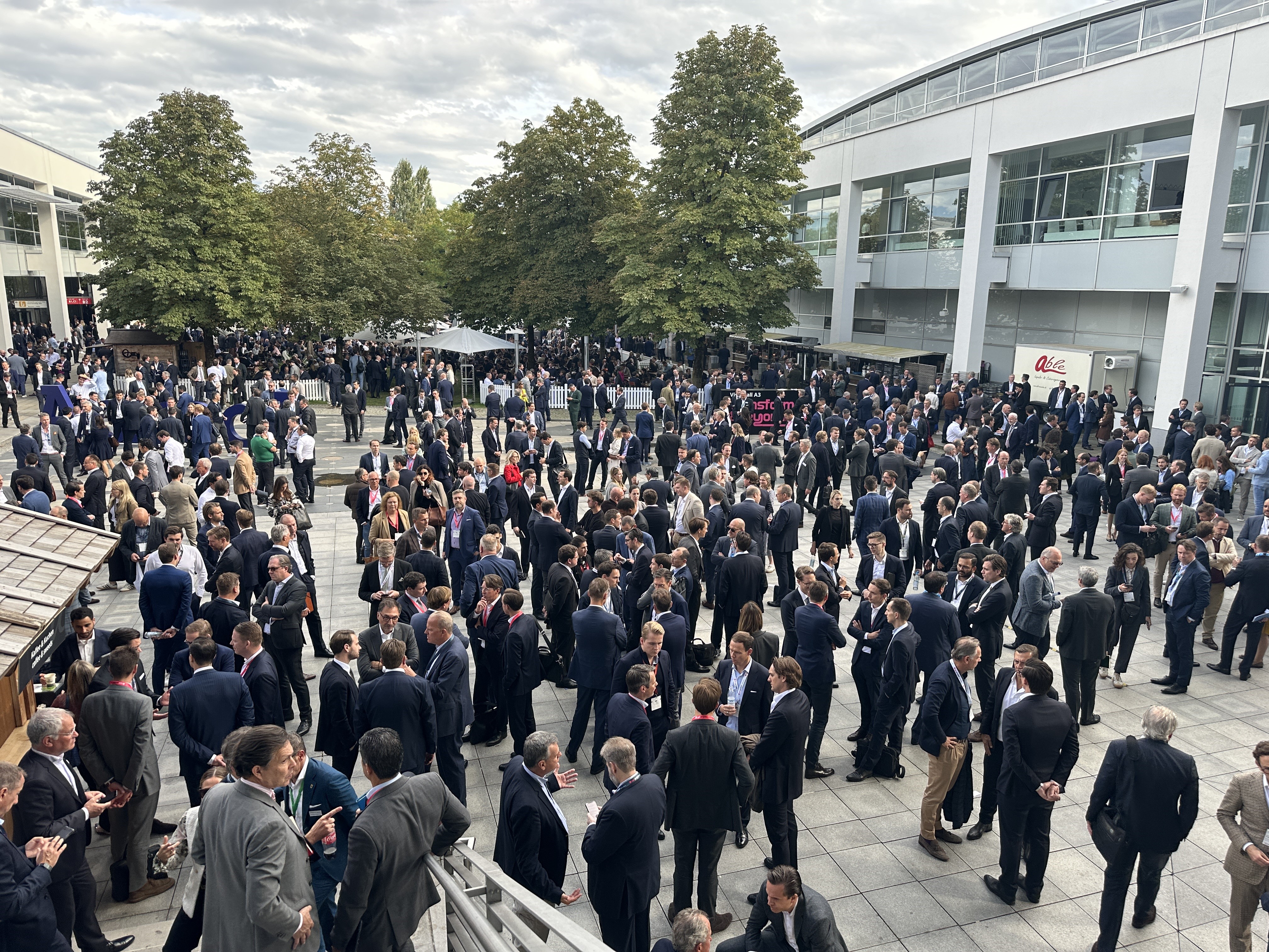 Über 40.000 Fachbesucher auf der EXPO Real 2024 – intensive Gespräche und Networking auch unter freiem Himmel, während Experten der Branche im klassischen dunkelblauen Anzug dominieren | BERLINboxx